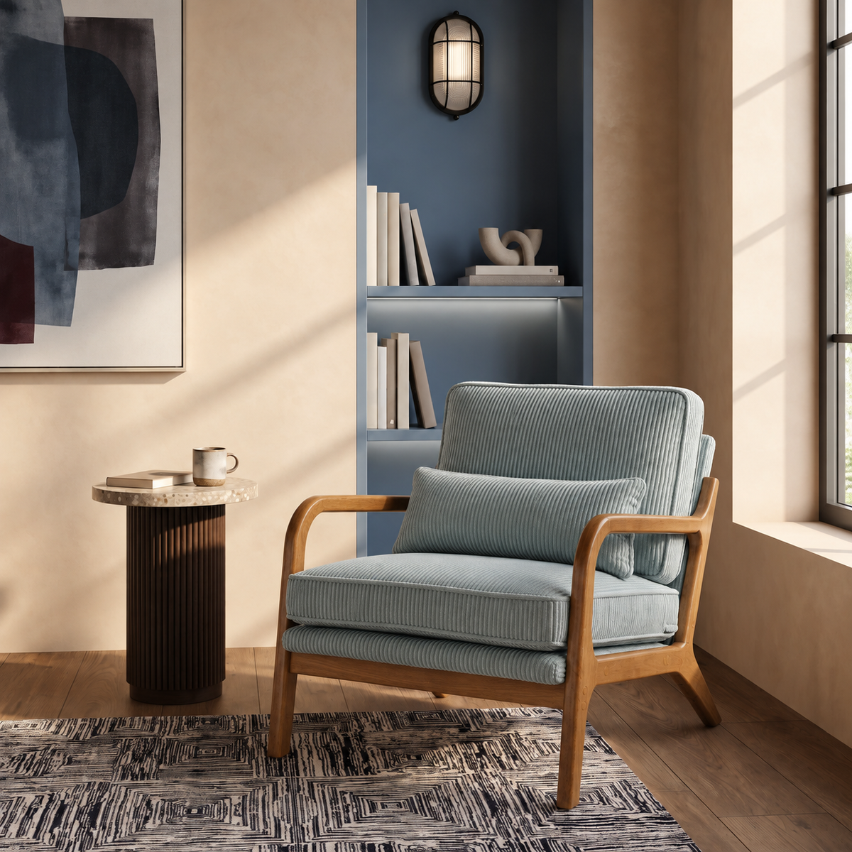 Fauteuil scandinave Colette en velours côtelé bleu-gris près d'une bibliothèque