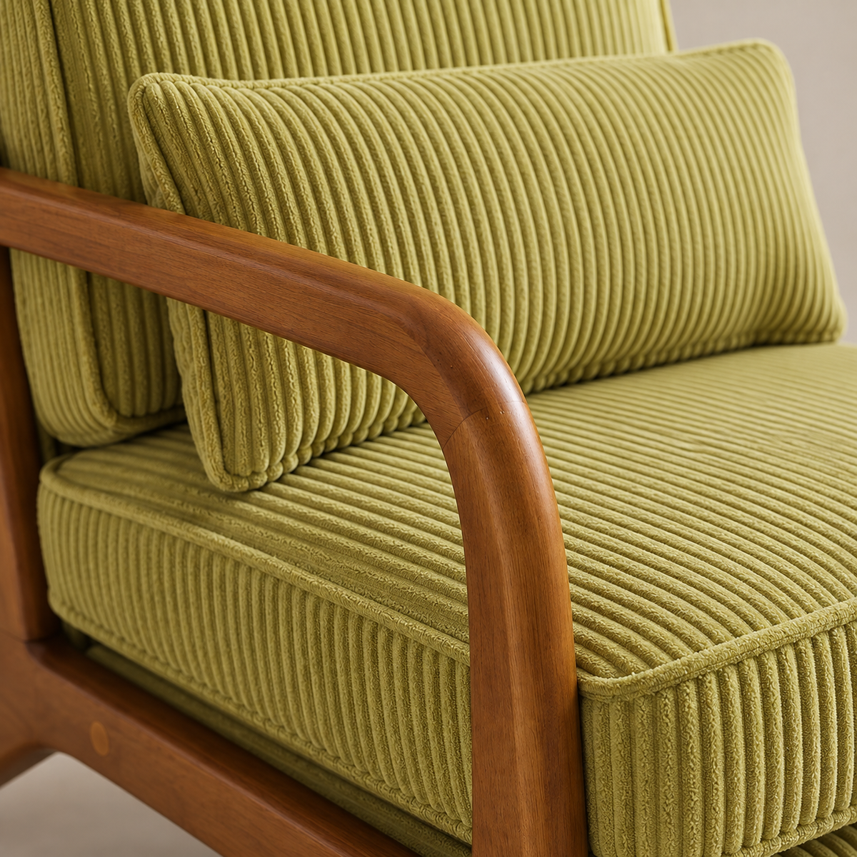 Détail de l'accoudoir en bois et du velours côtelé pistache du fauteuil Colette